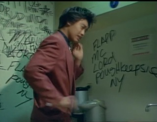 Low quality screenshot from Mirai Sentai Timeranger featuring wall graffiti that mentions Poughkeepsie NY